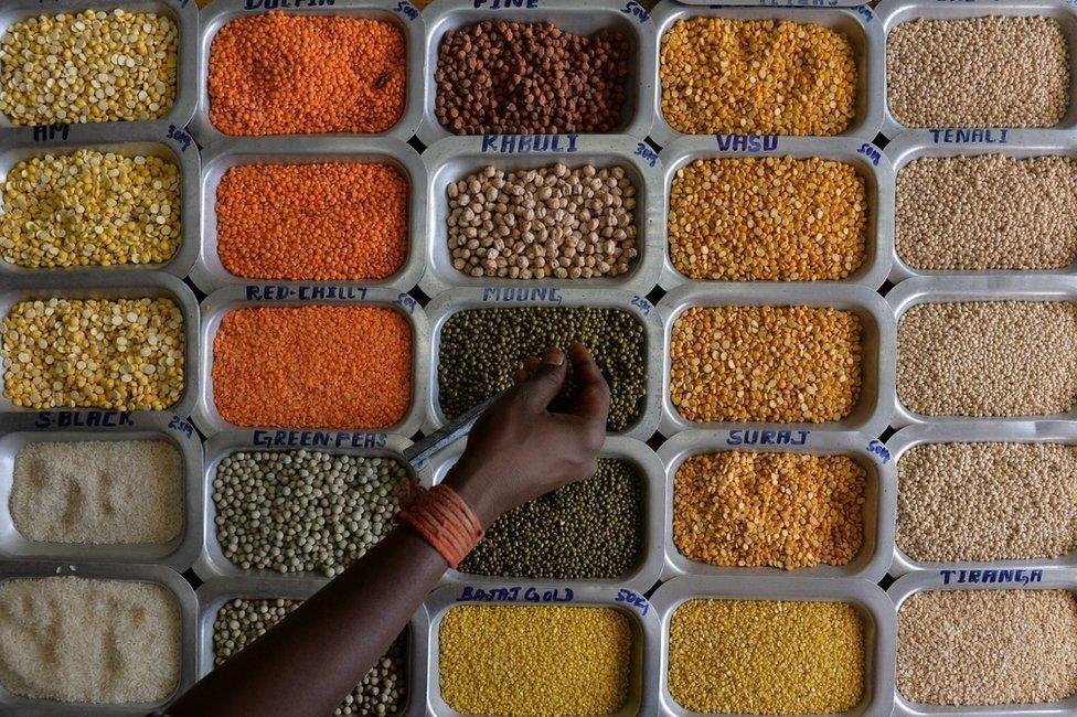 An Indian shopper examines pulses and food grains at a shop at the Agricultural Produce Marketing Committee (APMC) Yard in Bangalore on October 29, 2014.