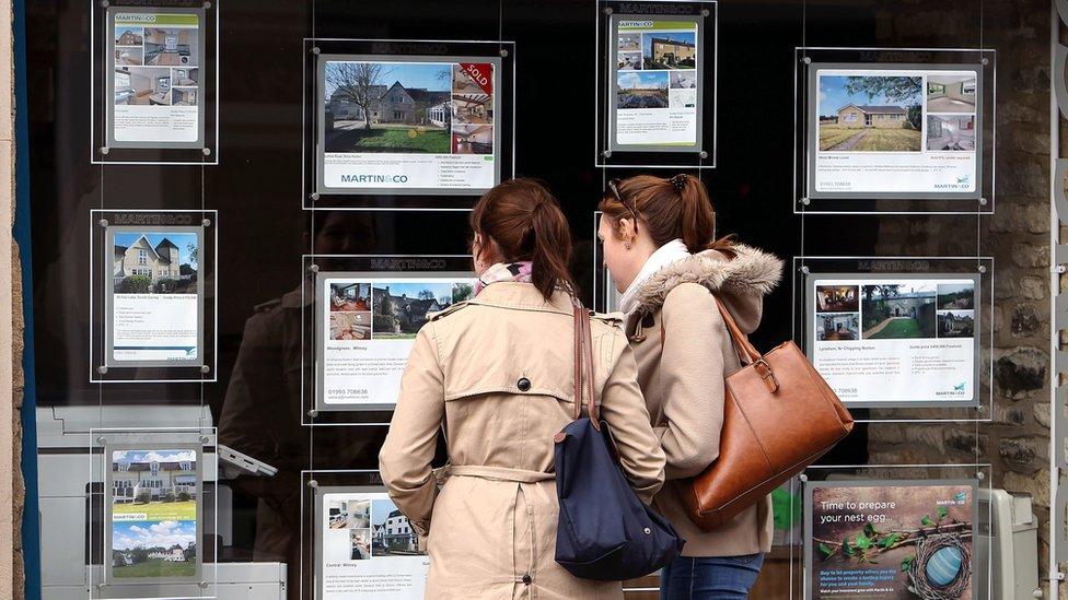 Two young women looking at an estate agent window - Witney, Oxfordshire 2016