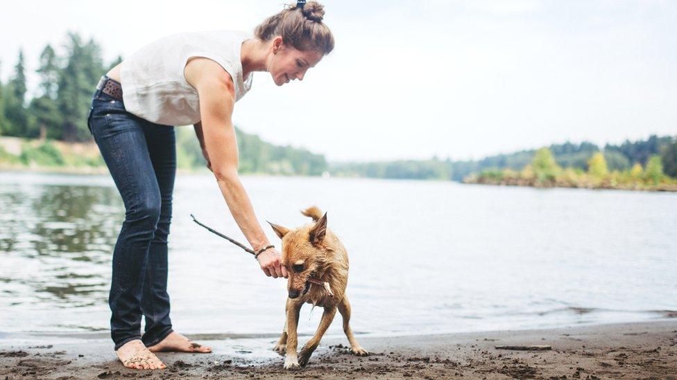 Woman with dog by water