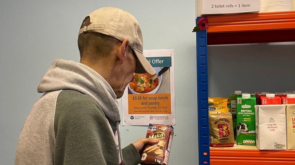 Man looks at food on a shelf