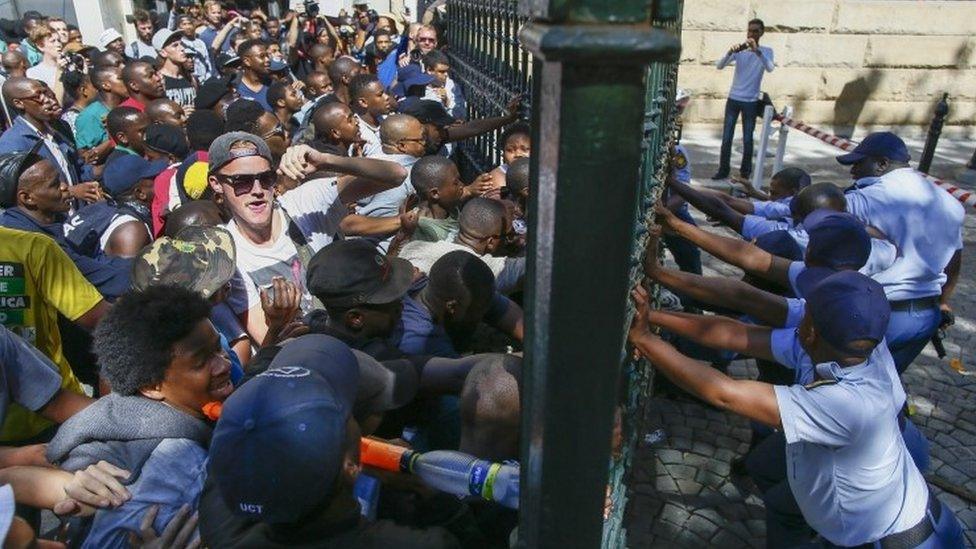 South African students force their way through the gates of parliament as police try to resist them, during violent clashes with police in the parliament precinct, Cape Town, South Africa, 21 October 2015