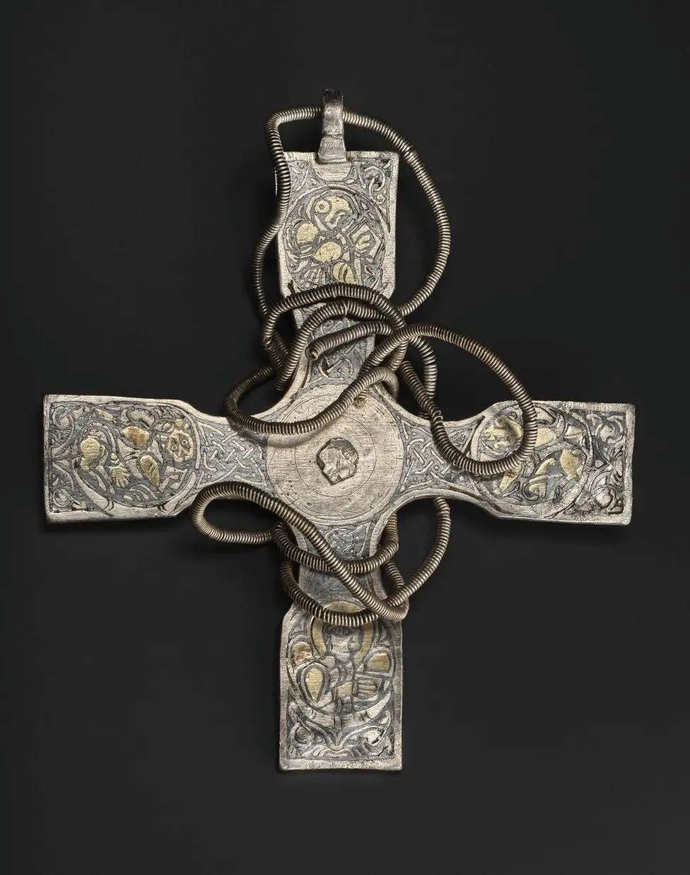 A silver Anglo-Saxon cross on a black background.