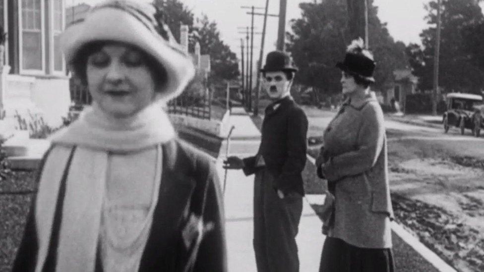 Charlie Chaplin watches as a woman passes by. Beside Chaplin, what we assume to be his wife looks angrily at him. It is visually very similar to the distracted boyfriend meme that was popular in 2017.