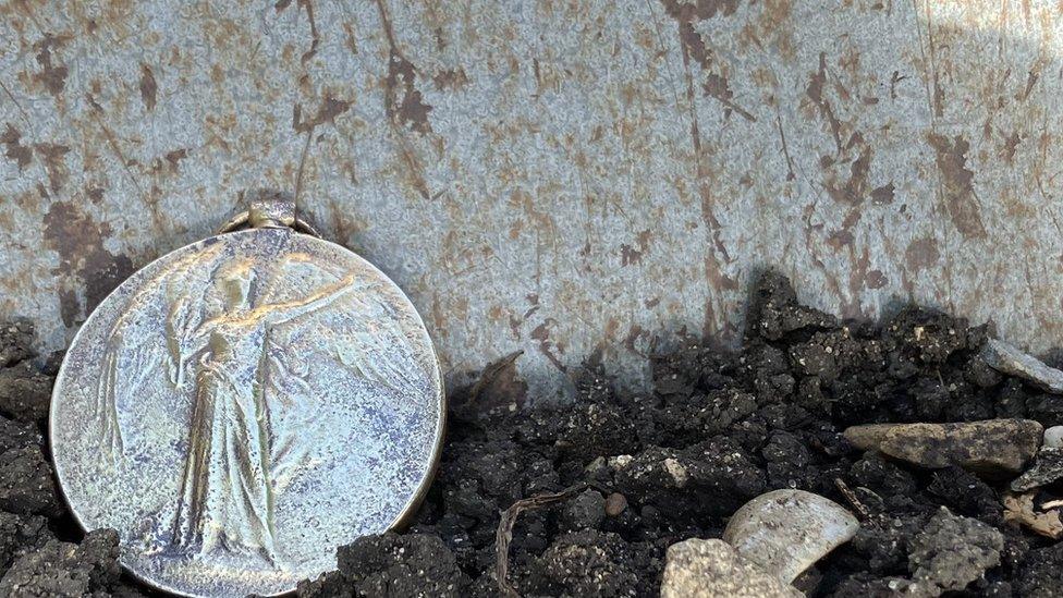 World War One medal on soil in front of spade