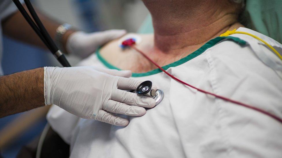 A doctor using a stethoscope on a patient in an Accident and Emergency department of a NHS national health service hospital