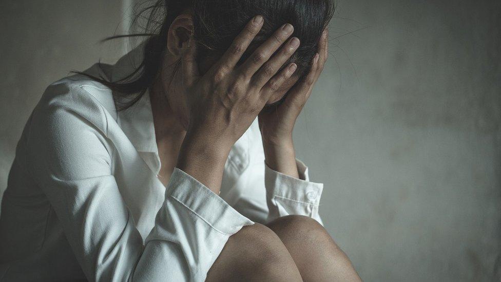 Stock image of a woman with her head in her hands