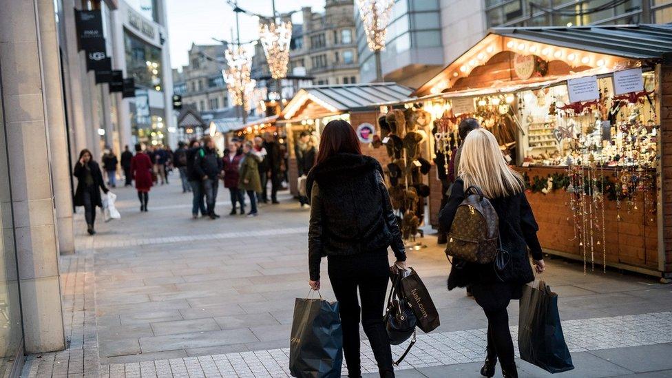 Shoppers walk by market