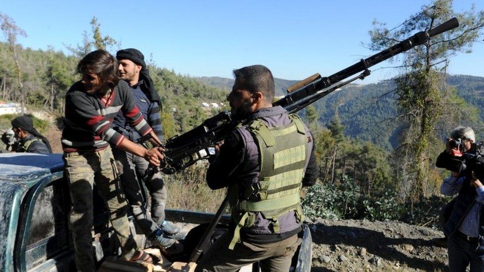 Syrian Turkmen fighters are seen with an anti-aircraft artillery weapon near the northern Syrian village of Yamadi (24 November 2015)