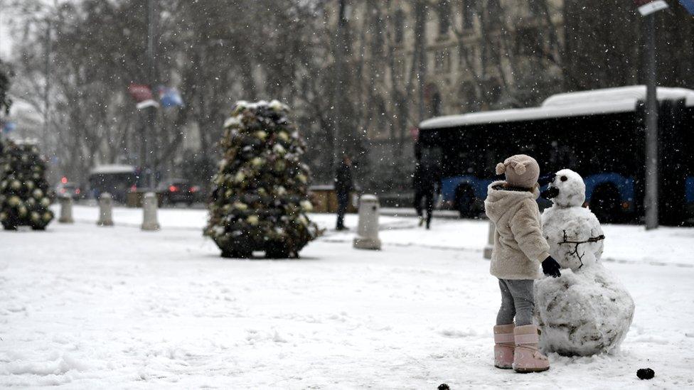 girl-makes-snowman