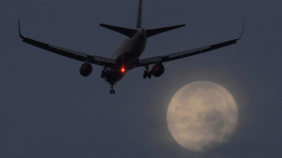 Plane lands in front of supermoon