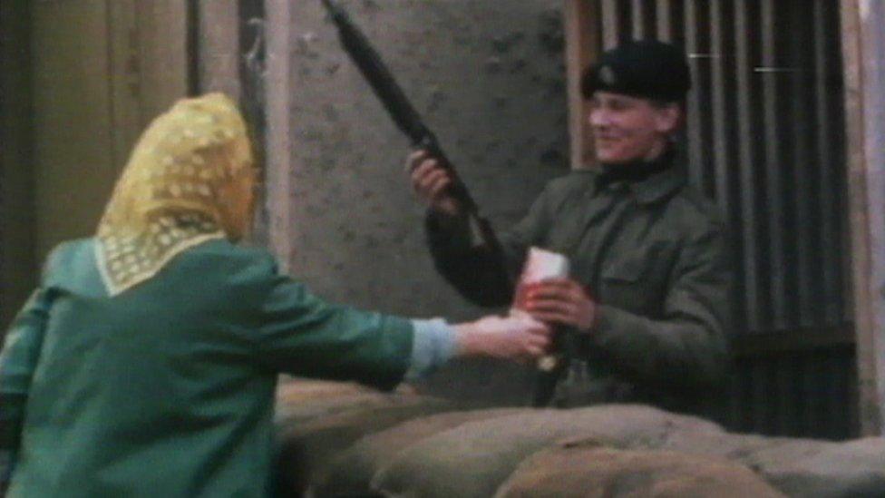 A soldier accepts a packet of biscuits from a woman in Belfast