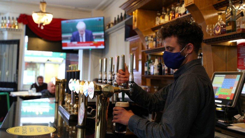 A member of staff pours a drink in the Richmond pub in Liverpool as Prime Minister Boris Johnson reads a statement on television, as parts of the North of England are bracing themselves for the most stringent Tier 3 controls, with Merseyside expected to have its pubs, gyms and casinos closed in a bid to suppress its infection rate.