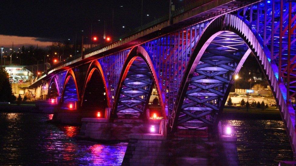 The International Peace Bridge, which connects Canada and the United States, illuminated in the colours of the French flag