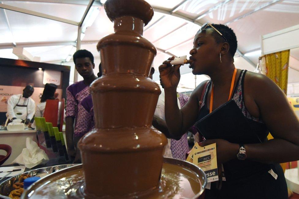 A woman tastes chocolate from a fountain in Abidjan, Ivory Coast - Saturday 1 October 2016