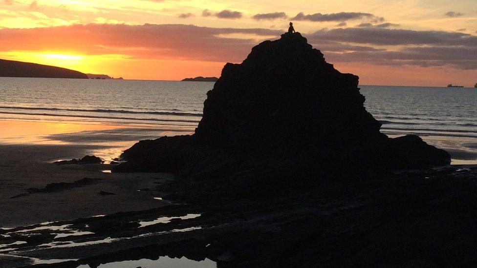 A girl on top of a rock at Broad Haven in Pembrokeshire