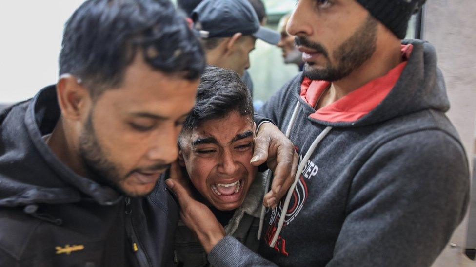 A Palestinian teenager reacts as bodies are brought to the mortuary at Nasser Hospital in Khan Younis, in the southern Gaza Strip (22 January 2024)