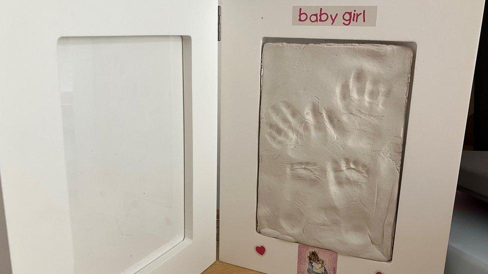 Image of baby hand and footprints in frame