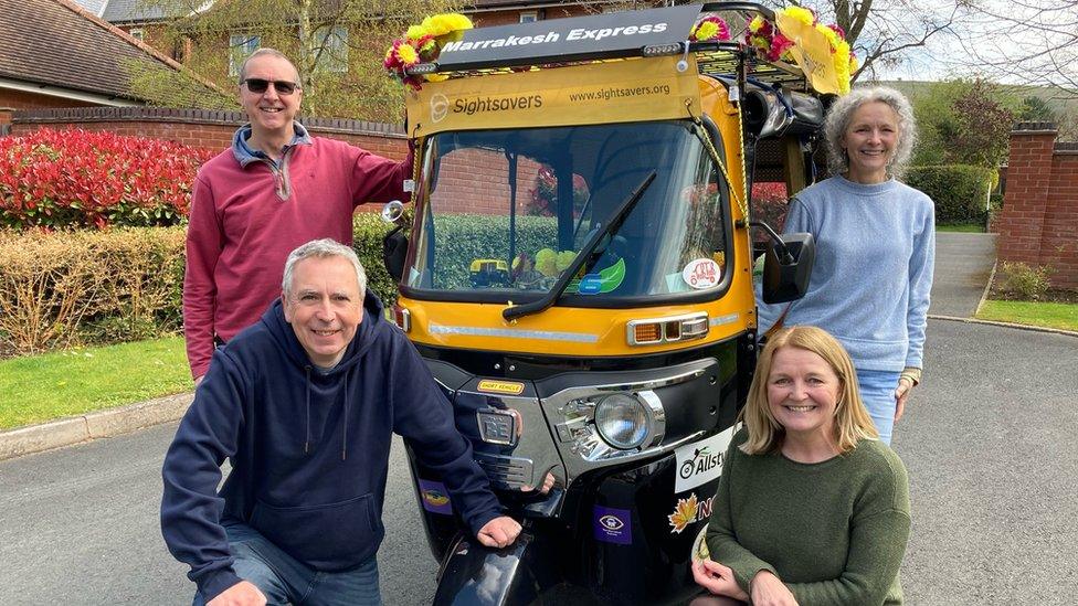 A group next to a tuk-tuk