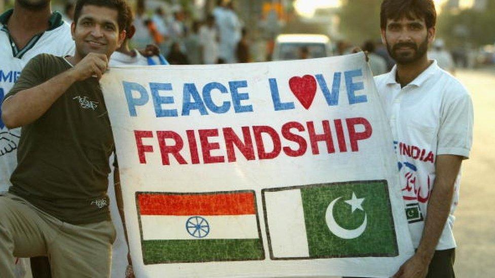 Cricket fans hold a sign which says 'Peace Love Friendship' after the first Pakistan v India one day international match played at the National Stadium March 13, 2004 in Karachi, Pakistan.