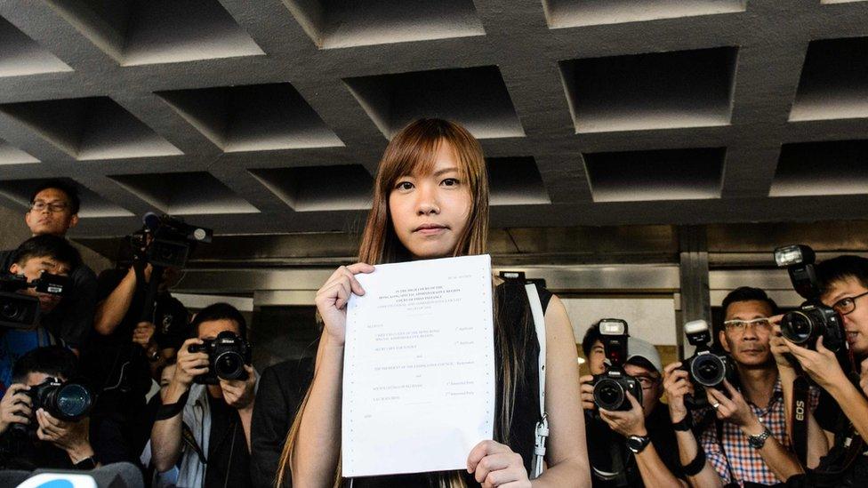 Pro-independence lawmaker Yau Wai-ching (C) holds a court ruling as she leaves the High Court in Hong Kong on November 15, 2016.