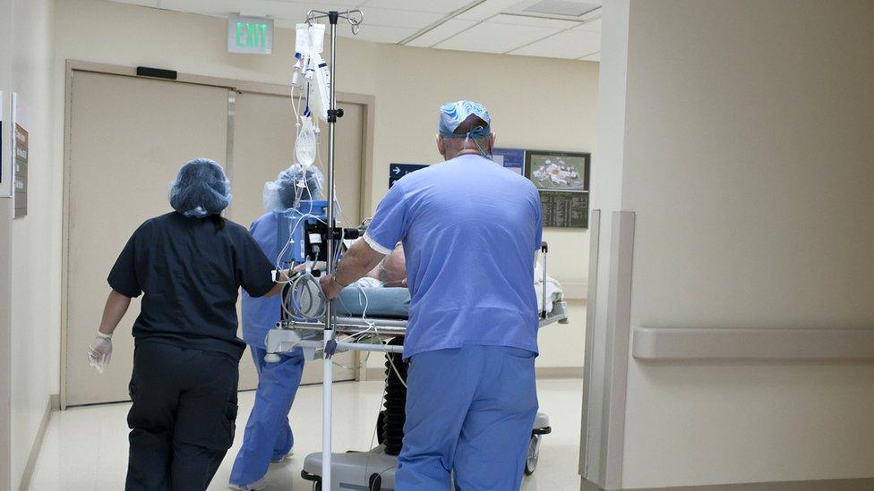 medics wheeling bed through corridor