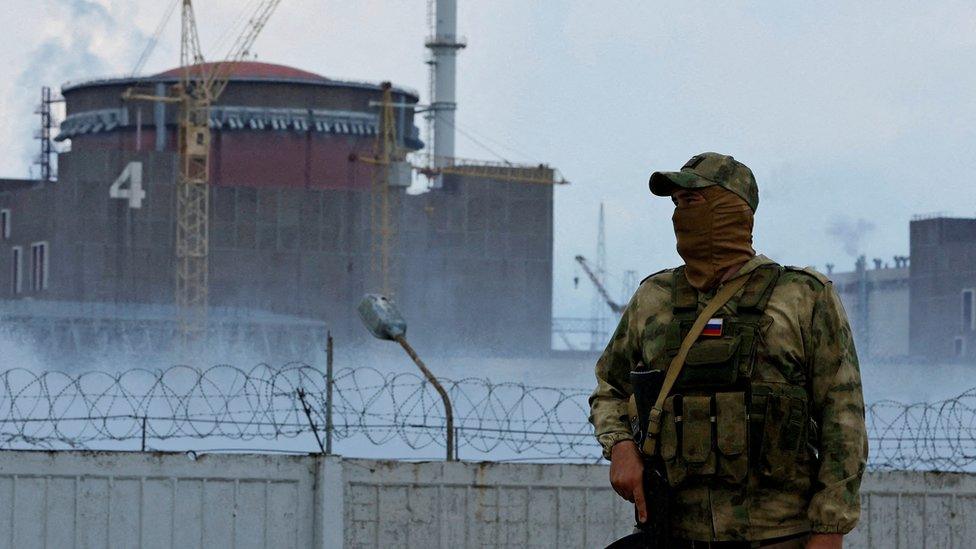 A serviceman with a Russian flag on his uniform stands guard near the Zaporizhzhia Nuclear Power Plant in the course of Ukraine-Russia conflict outside the Russian-controlled city of Enerhodar in the Zaporizhzhia region, Ukraine August 4, 2022