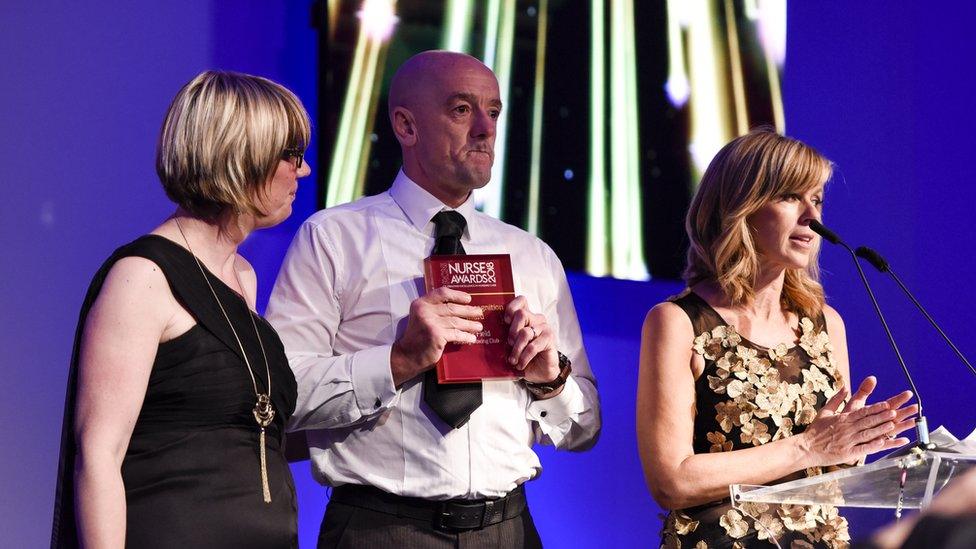 Mark Field accepting his award from Kate Garraway and Emilia Clarke