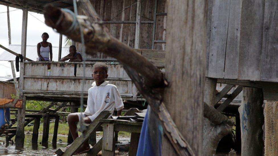 A child sits outside a house