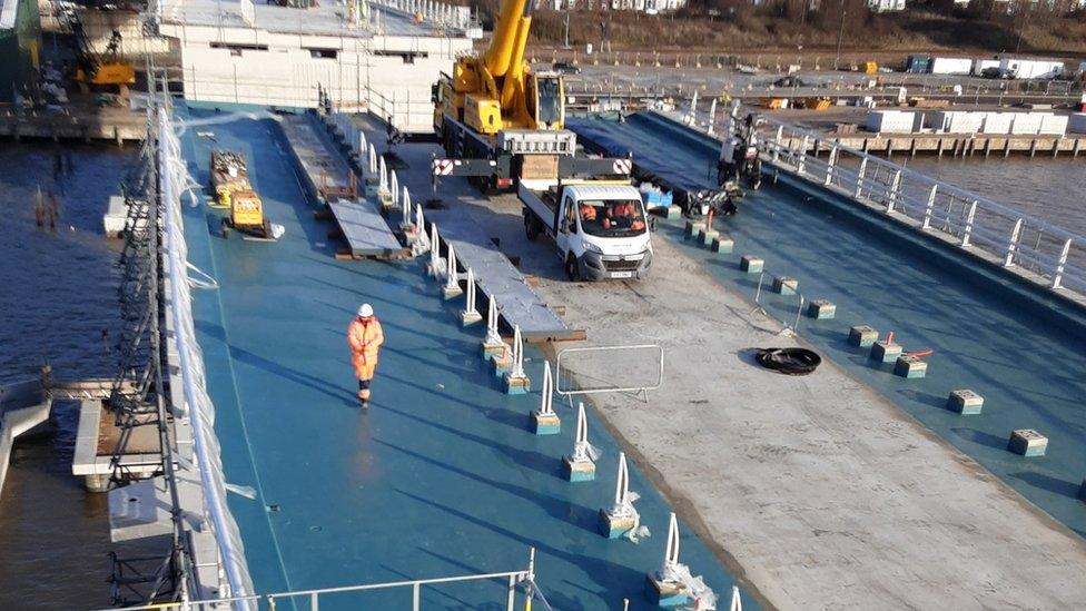 Work continuing on the bridge, with part of it covered in blue tarps.