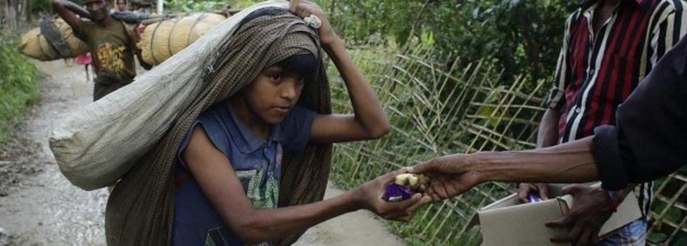 Rohingya refugees receive bread and bananas from local people as they arrive in Tuangiri, Teknaf, Bangladesh (12 September 2017)