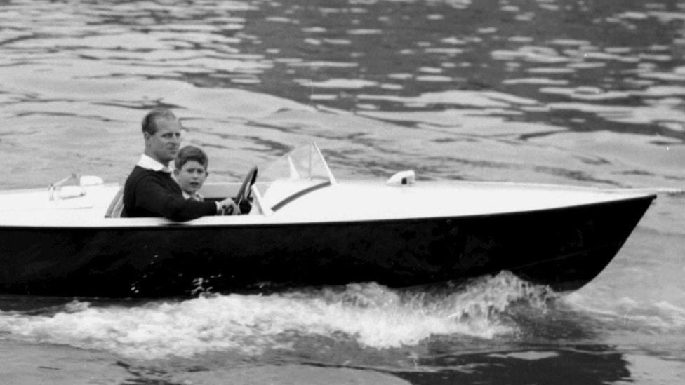 Prince Philip with a young Prince Charles on the River Medina in 1957