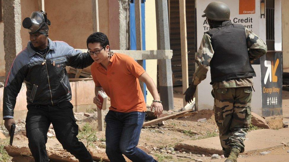 Malian security forces evacuate a man from the hotel