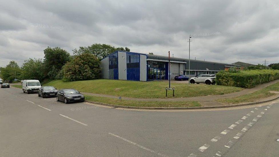 A blue and grey warehouse building on an industrial estate