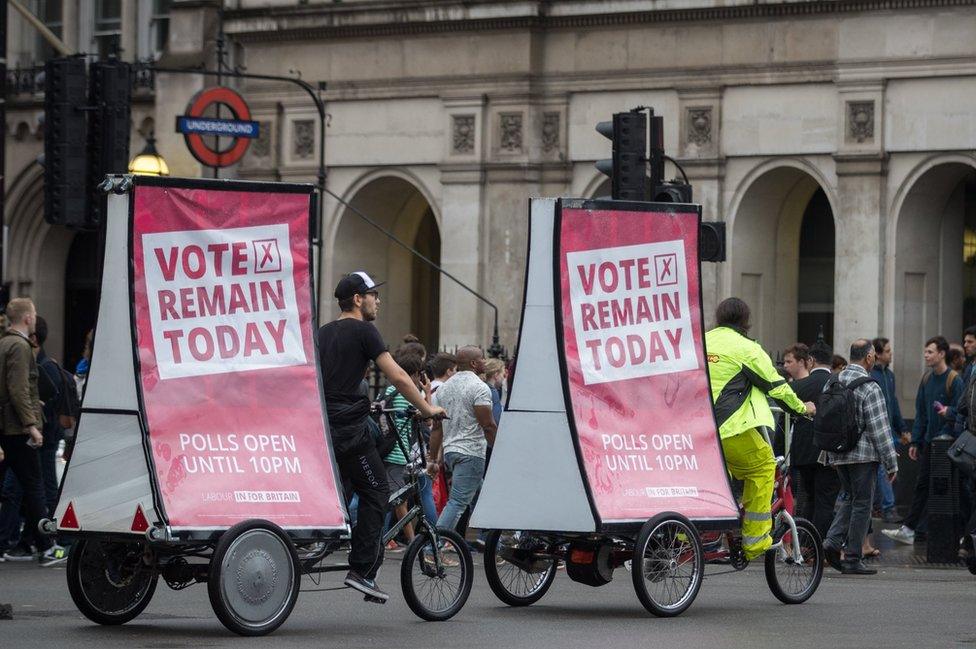 Cyclists with vote remain posters pass Big Ben