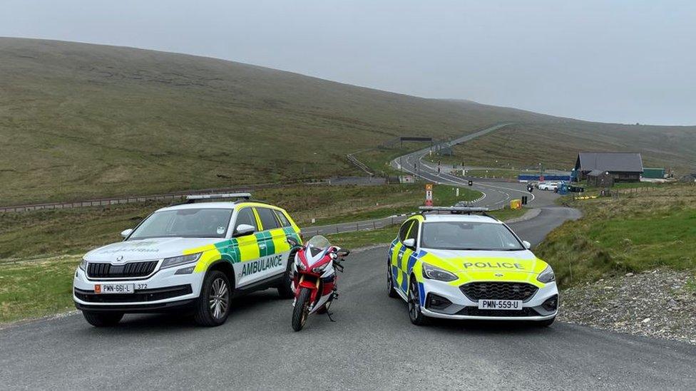 Ambulance, motorbike and police car parked on the Mountain Road by the Bungalow