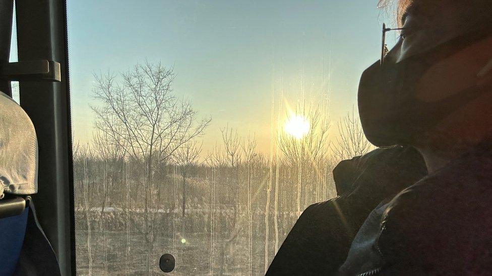 Yuwen looks out of the window during a journey on public transport