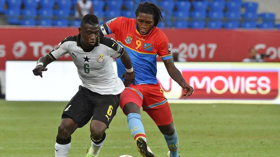 Dieumerci Mbokani (R) challenges Ghana's midfielder Afriyie Acquah