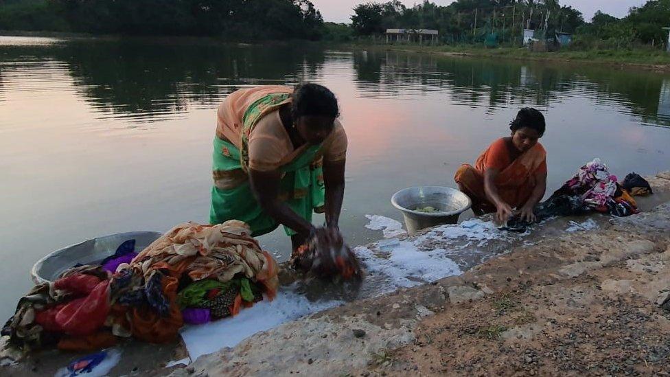 Women hand washing clothes