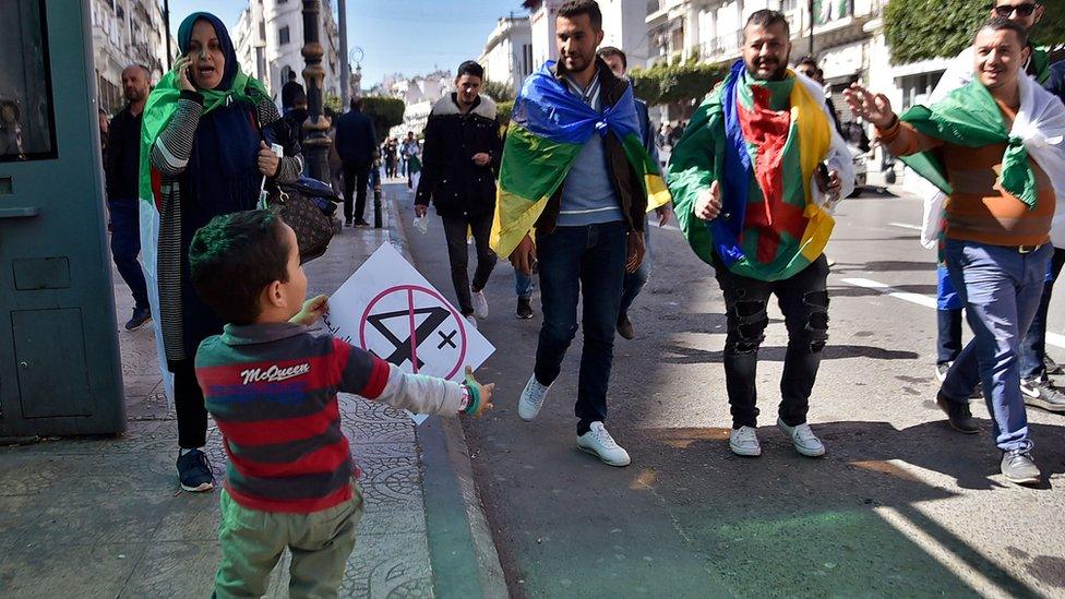 A child holds a protest sign