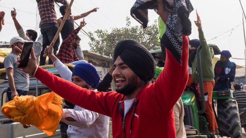 Farmers celebrate after India's Prime Minister announced to repeal three agricultural reform laws that sparked almost a year of huge protests by farmers across the country in Singhu on November 19, 2021