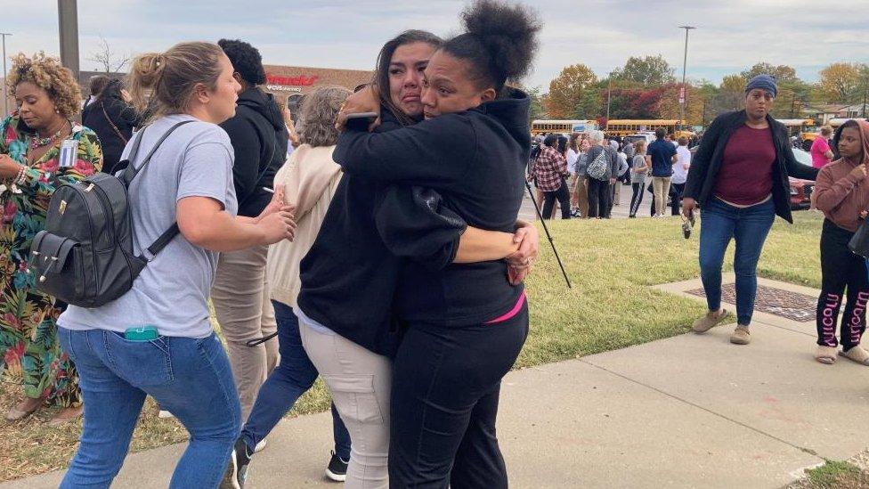 People embrace outside the school