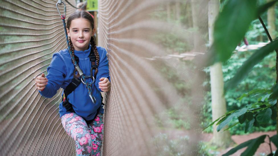 A girl making her way along a Go Ape walkway