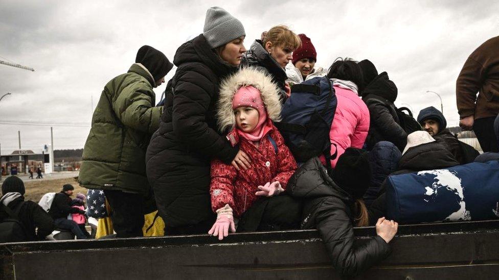 A child looks on as residents evacuate the city of Irpin, northwest of Kyiv, 5 March 2022