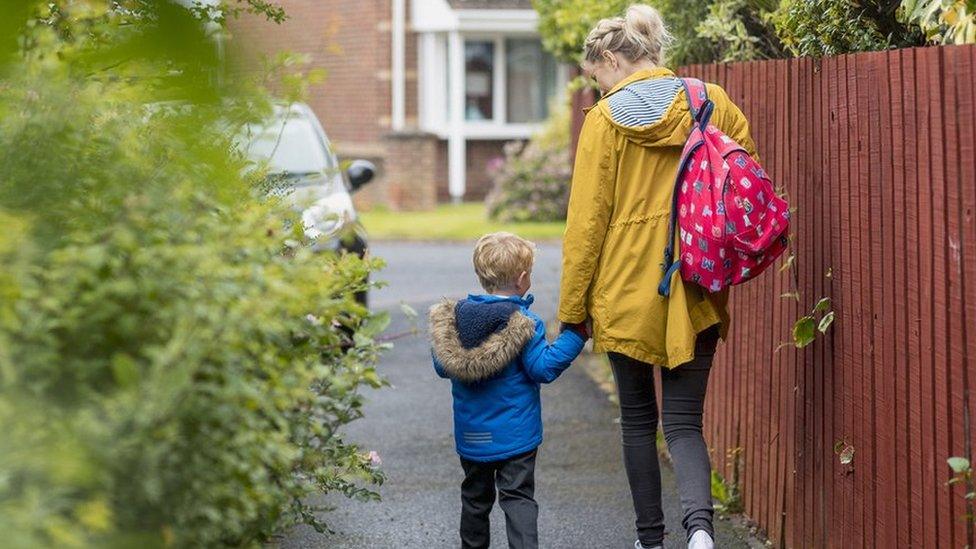 A parent and child walk to school