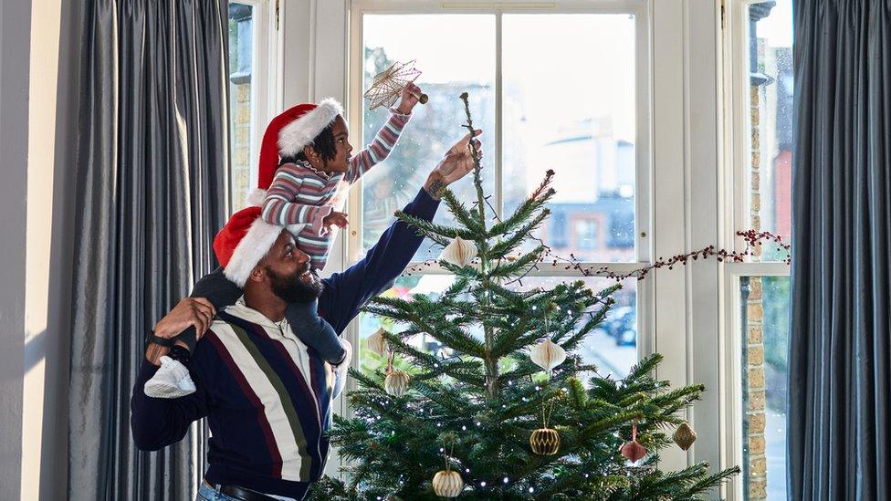 girl-and-dad-putting-star-on-tree.