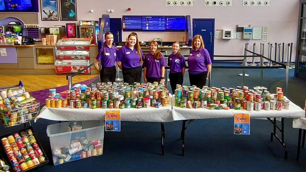 Cinema staff with some of the donated cans