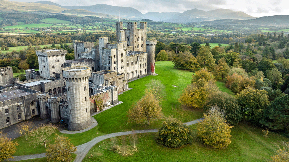 Drone view of the white stone Penrhyn Castle set against the green Welsh countryside 