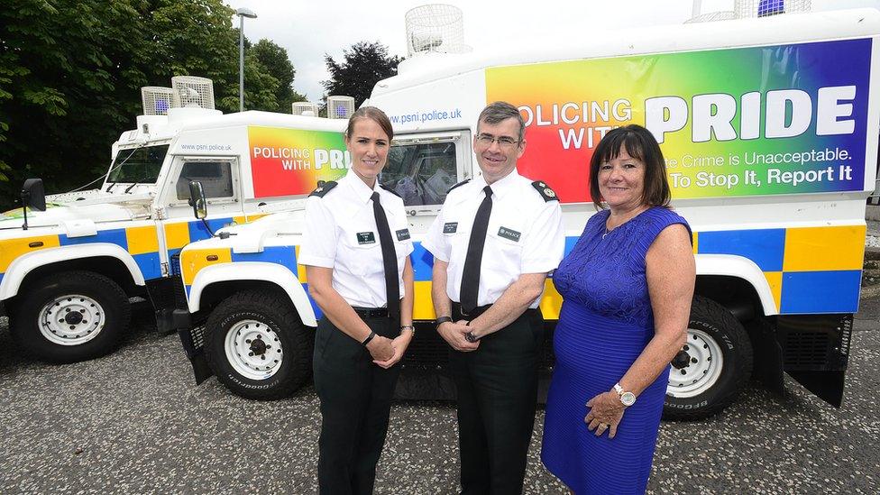 Police officer stand with 'Pride' Land Rovers