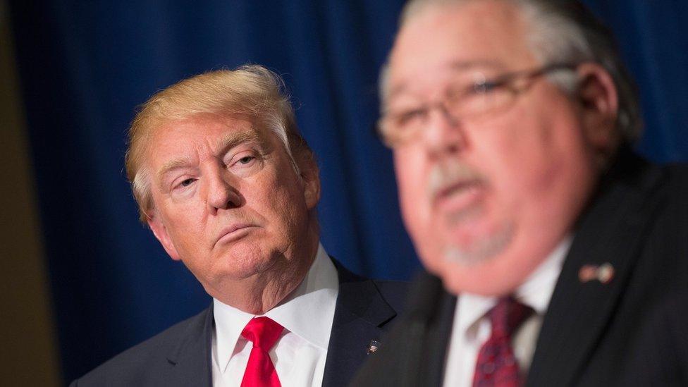 Republican presidential candidate Donald Trump (L) listens as Sam Clovis speaks in Dubuque, Iowa, on 25 August 2015