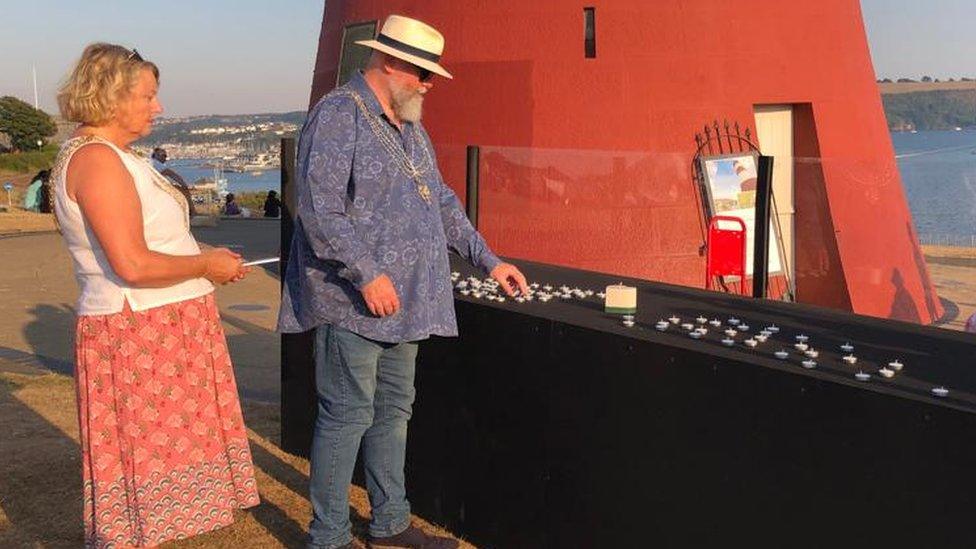 Candles are lit at Smeaton's Tower in Plymouth in a gathering of the wider city community